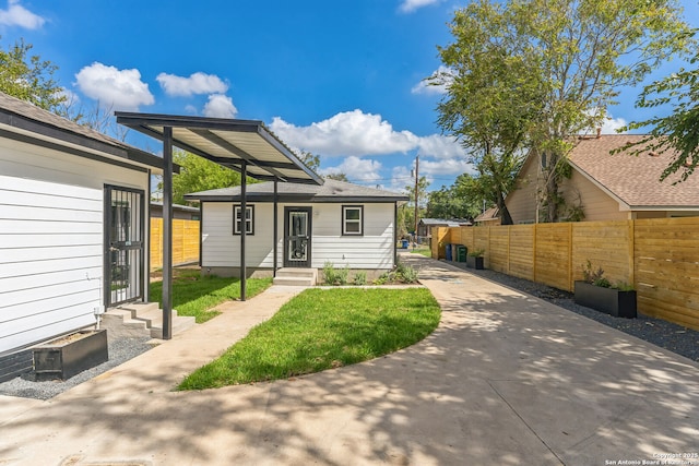 rear view of property with entry steps and fence