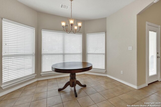 unfurnished dining area with visible vents, tile patterned flooring, a notable chandelier, and a healthy amount of sunlight