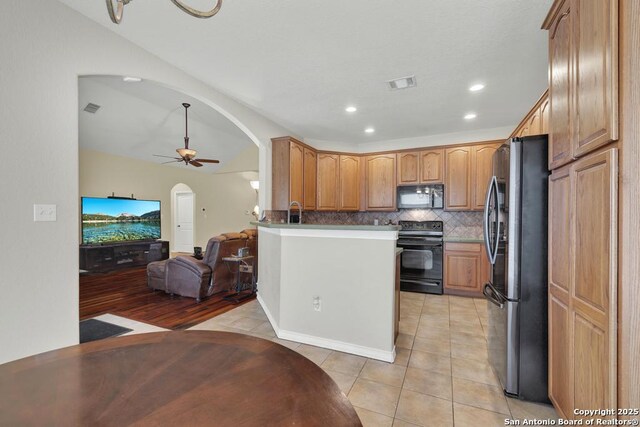 kitchen with a ceiling fan, black appliances, open floor plan, arched walkways, and visible vents