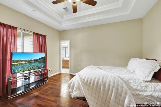 bedroom with hardwood / wood-style floors, a raised ceiling, visible vents, ornamental molding, and baseboards
