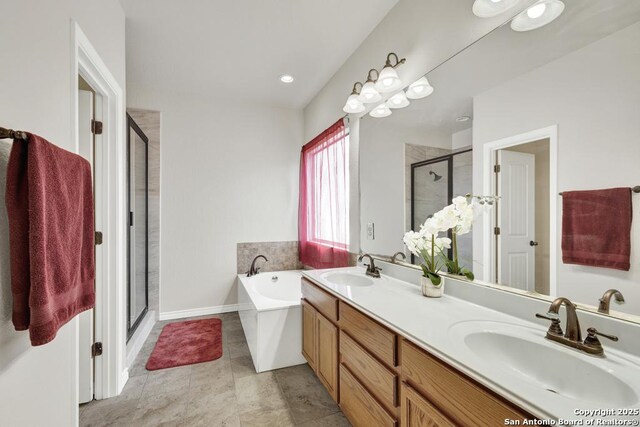 bathroom featuring double vanity, a bath, a stall shower, and a sink