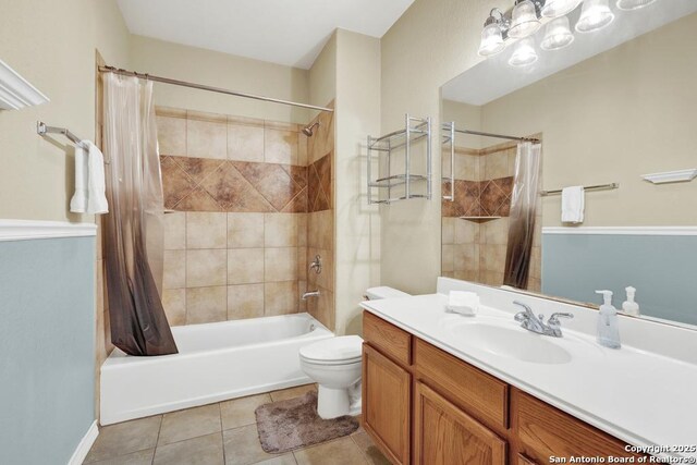 full bathroom featuring toilet, an inviting chandelier, shower / bath combo with shower curtain, tile patterned flooring, and vanity
