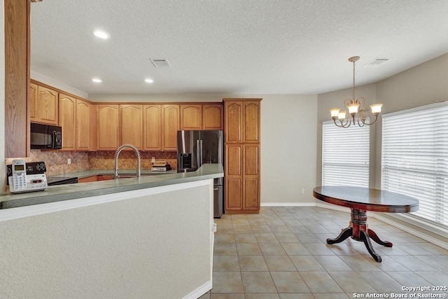 kitchen featuring a sink, black microwave, backsplash, baseboards, and stainless steel refrigerator with ice dispenser