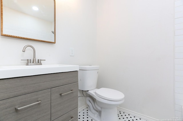 bathroom featuring baseboards, tile patterned flooring, vanity, and toilet