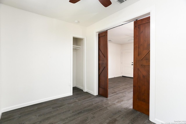 unfurnished bedroom with a ceiling fan, baseboards, dark wood-style flooring, and a closet