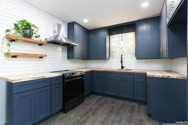 kitchen with wood counters, wall chimney exhaust hood, blue cabinetry, and electric range