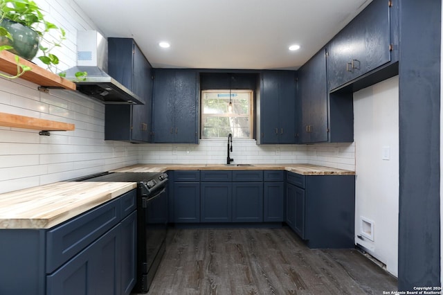 kitchen with a sink, blue cabinets, black / electric stove, butcher block counters, and wall chimney exhaust hood