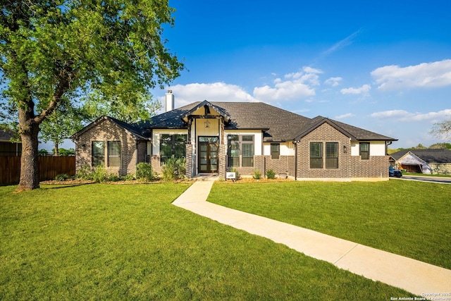 132 Ash Pkwy, La Vernia, TX 78121 - view of front of house with brick siding, a chimney, a front yard, and fence