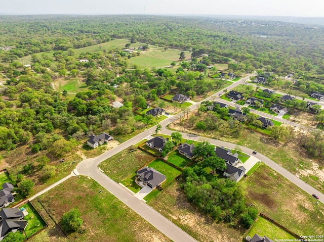drone / aerial view featuring a residential view and a wooded view