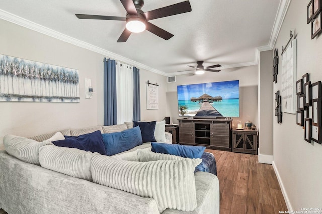 living room featuring visible vents, baseboards, a ceiling fan, wood finished floors, and crown molding