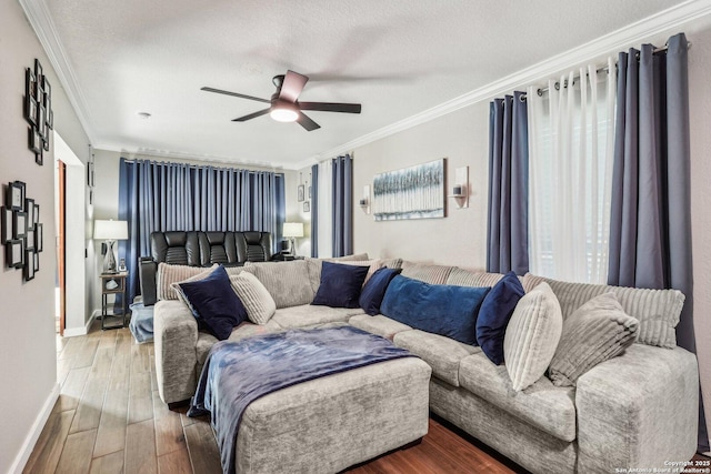 living room with baseboards, a ceiling fan, wood finished floors, and crown molding