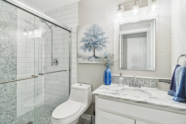 bathroom featuring a textured wall, a shower stall, and toilet