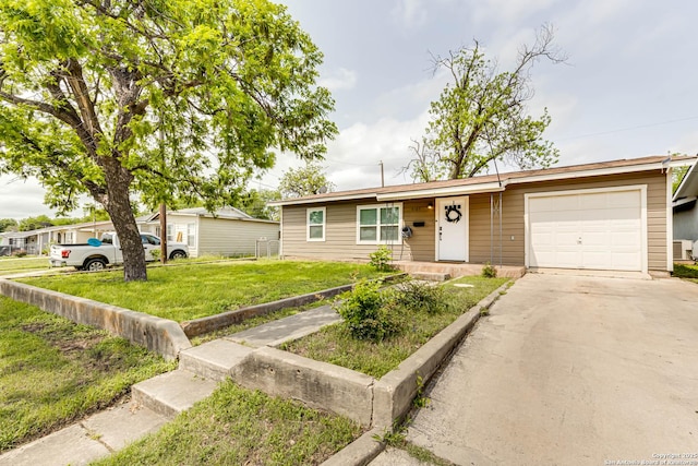 single story home with driveway, a front yard, and a garage