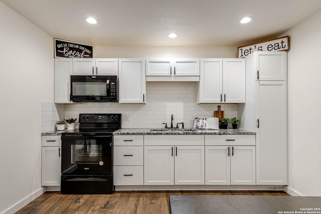 kitchen with light stone counters, backsplash, a sink, and black appliances