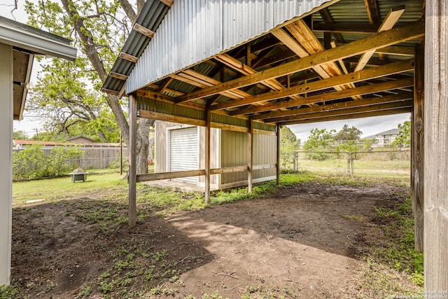 exterior space featuring a carport, an outbuilding, and fence