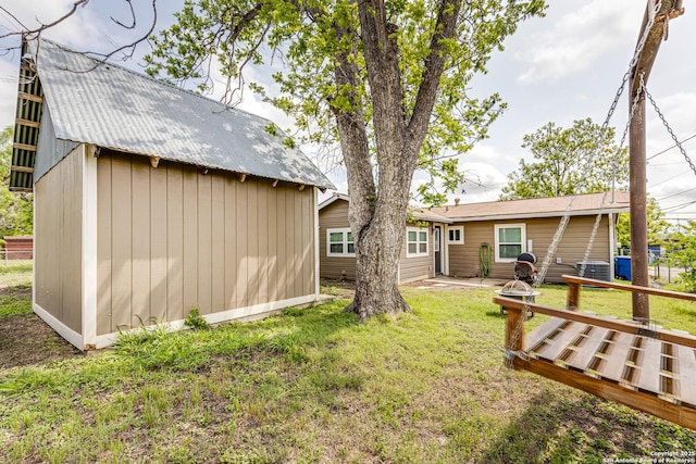 view of yard with a storage shed, cooling unit, an outbuilding, and a deck
