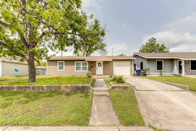 ranch-style home featuring an attached garage, driveway, fence, and a front lawn