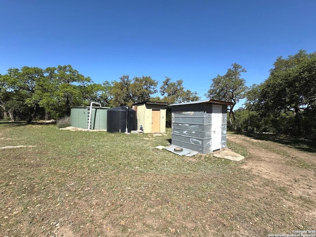 view of yard with a storage shed and an outbuilding