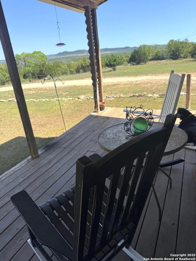 deck featuring outdoor dining area and a yard