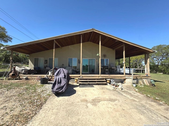 rear view of house with stucco siding and a deck