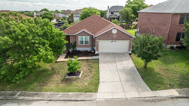view of front of home with concrete driveway, a front lawn, brick siding, and a garage