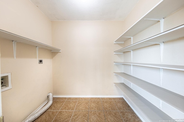laundry area with hookup for an electric dryer, washer hookup, laundry area, baseboards, and tile patterned flooring
