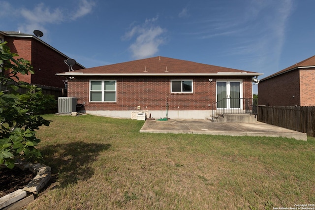 back of property featuring brick siding, a yard, a patio, and fence