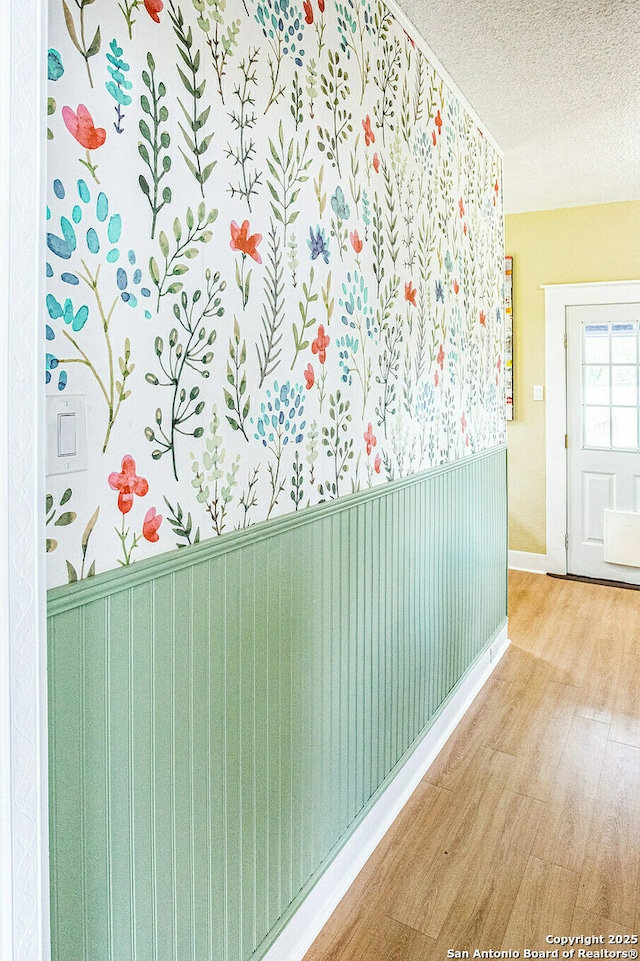 hallway featuring wood finished floors and a textured ceiling