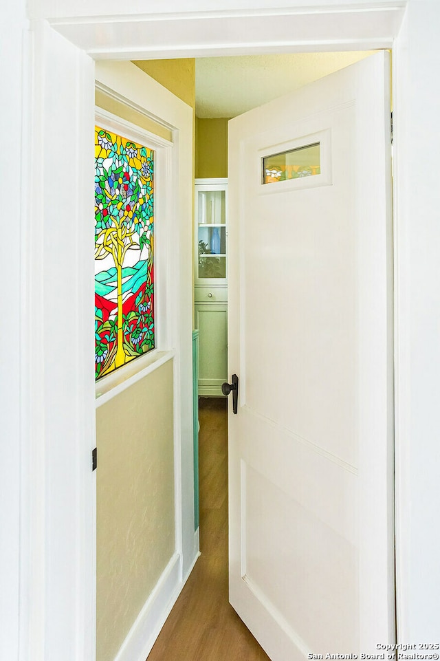 hallway with baseboards and wood finished floors