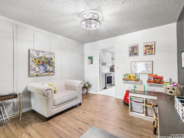 7906 Winsford, San Antonio, TX 78239 - living room featuring baseboards, a textured ceiling, and light wood-style floors