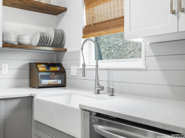 7906 Winsford, San Antonio, TX 78239 - details featuring open shelves, dishwasher, a sink, and light stone counters