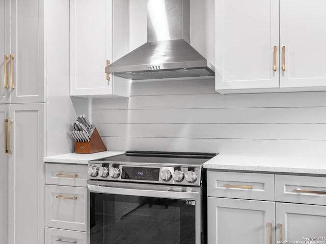 7906 Winsford, San Antonio, TX 78239 - kitchen with wall chimney exhaust hood, stainless steel electric stove, and white cabinets