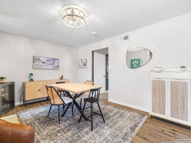 7906 Winsford, San Antonio, TX 78239 - dining area with wood finished floors, visible vents, and a textured ceiling