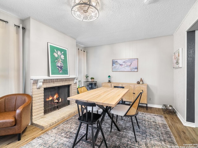 7906 Winsford, San Antonio, TX 78239 - dining space featuring baseboards, a brick fireplace, wood finished floors, and a textured ceiling