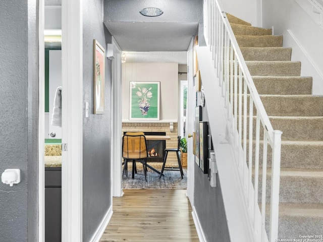 7906 Winsford, San Antonio, TX 78239 - corridor featuring wood finished floors, a textured wall, baseboards, and stairway