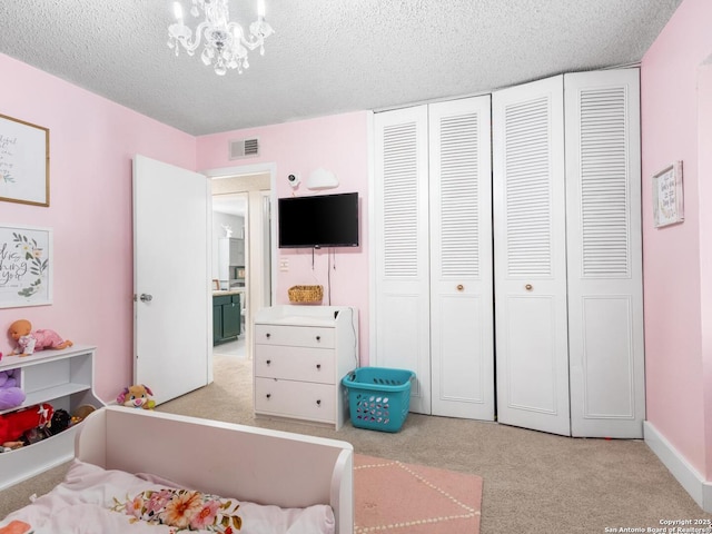 7906 Winsford, San Antonio, TX 78239 - carpeted bedroom with an inviting chandelier, a textured ceiling, visible vents, and a closet