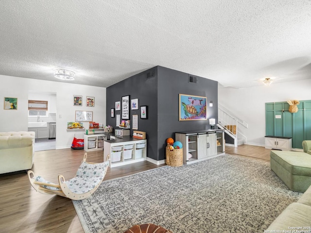 7906 Winsford, San Antonio, TX 78239 - living area with stairway, wood finished floors, a textured ceiling, baseboards, and visible vents