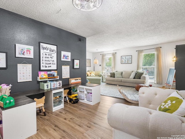 7906 Winsford, San Antonio, TX 78239 - living room with wood finished floors, visible vents, and a textured ceiling