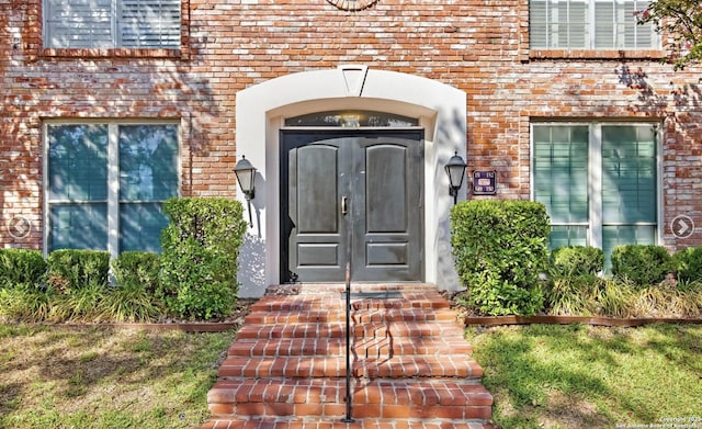 entrance to property featuring french doors and brick siding