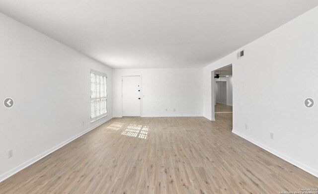 interior space with baseboards, visible vents, and light wood-type flooring