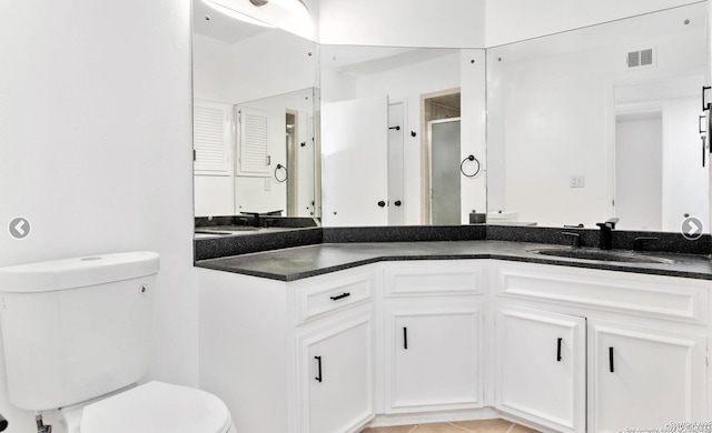 bathroom with a shower stall, tile patterned floors, visible vents, toilet, and vanity
