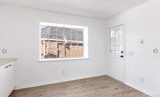 unfurnished dining area featuring baseboards, wood finished floors, and a wealth of natural light