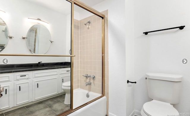 full bath with toilet, vanity, tile patterned floors, and combined bath / shower with glass door