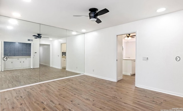 unfurnished living room featuring light wood-type flooring and ceiling fan