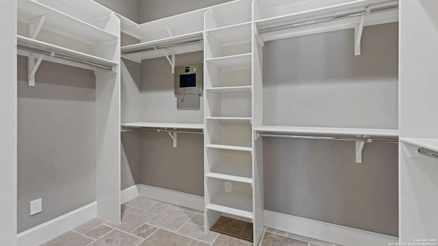 spacious closet with stone tile flooring