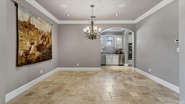 unfurnished dining area with arched walkways, stone tile floors, crown molding, and baseboards