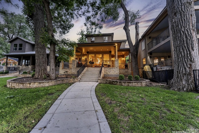 exterior space featuring stairway, a lawn, and a porch