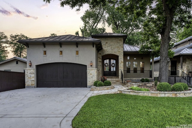 view of front of home featuring french doors, a standing seam roof, stone siding, metal roof, and stucco siding