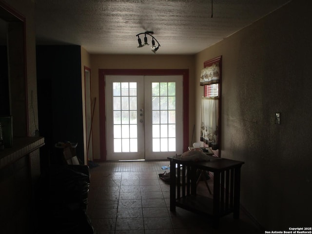 doorway to outside with french doors and a textured ceiling