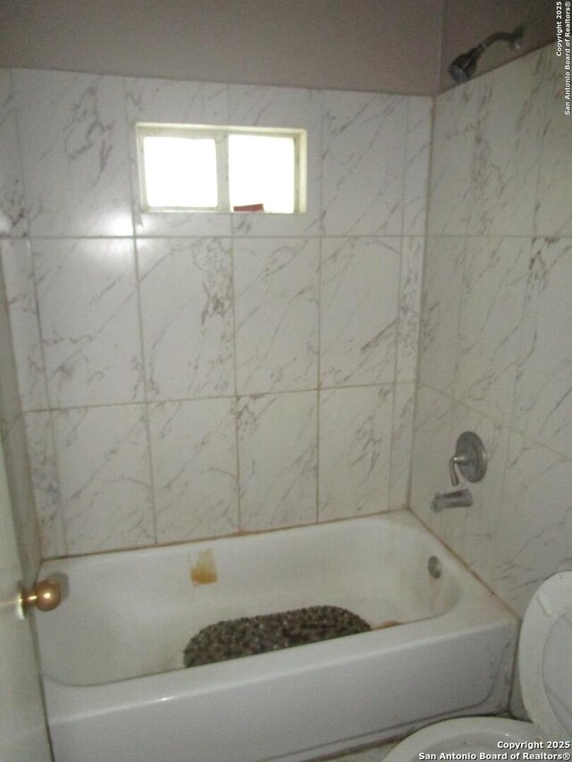 full bath with washtub / shower combination and toilet
